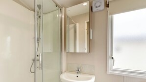 A modern bathroom with a glass shower enclosure, a white sink, and a window. - Silver 3 Bedroom Caravan, Sleeps 8 (Ryde, Nr Bembridge)