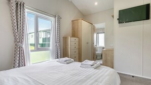 Una camera da letto con un letto, un armadio, una televisione e vista all'esterno.