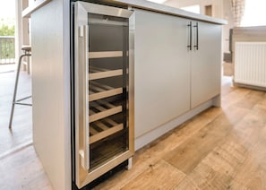A modern kitchen with a built-in oven, stainless steel cabinets, and a wooden floor. - Prestige Lodge, parking, ensuite, decking & SV 4 (Ryde, Nr Bembridge)