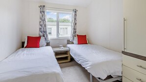 Ein Schlafzimmer mit zwei Einzelbetten, einem kleinen Tisch und einem Kleiderschrank.