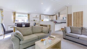 Ein modernes Wohnzimmer mit einer Couch, einem Couchtisch und einem Essbereich mit Stühlen und einem Tisch.