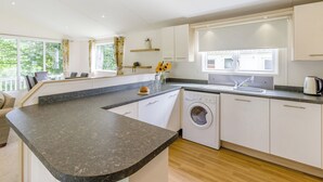 Eine moderne Küche mit Granit Arbeitsplatte, integrierten Geräten und Blick auf Grünflächen.