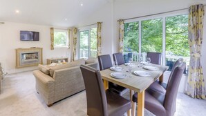 Un comedor con una mesa dispuesta para cuatro, un sofá y una chimenea.