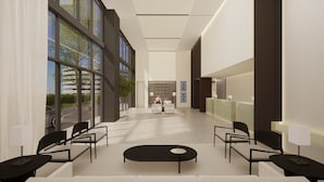 A modern hotel lobby with a reception desk, seating area, and large windows. - Laghetto Stilo Aeroporto (Porto Alegre)