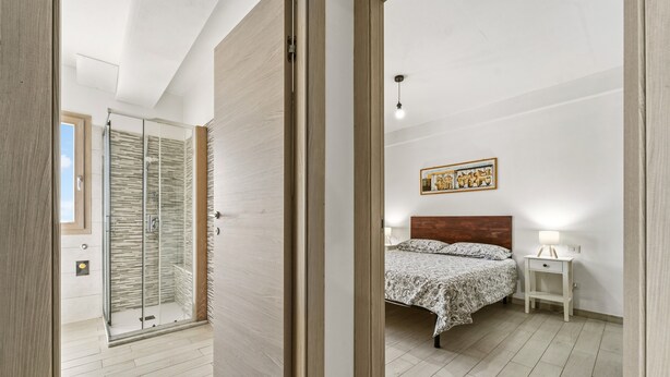 Un dormitorio con cama, mesita de noche y velador.