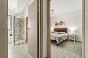A bedroom with a bed, bedside table, and a nightstand. - Casa Due Spighe San Sperate (San Sperate)