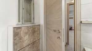 Una habitación con un armario de madera, un mueble y una puerta que da a otra habitación.
