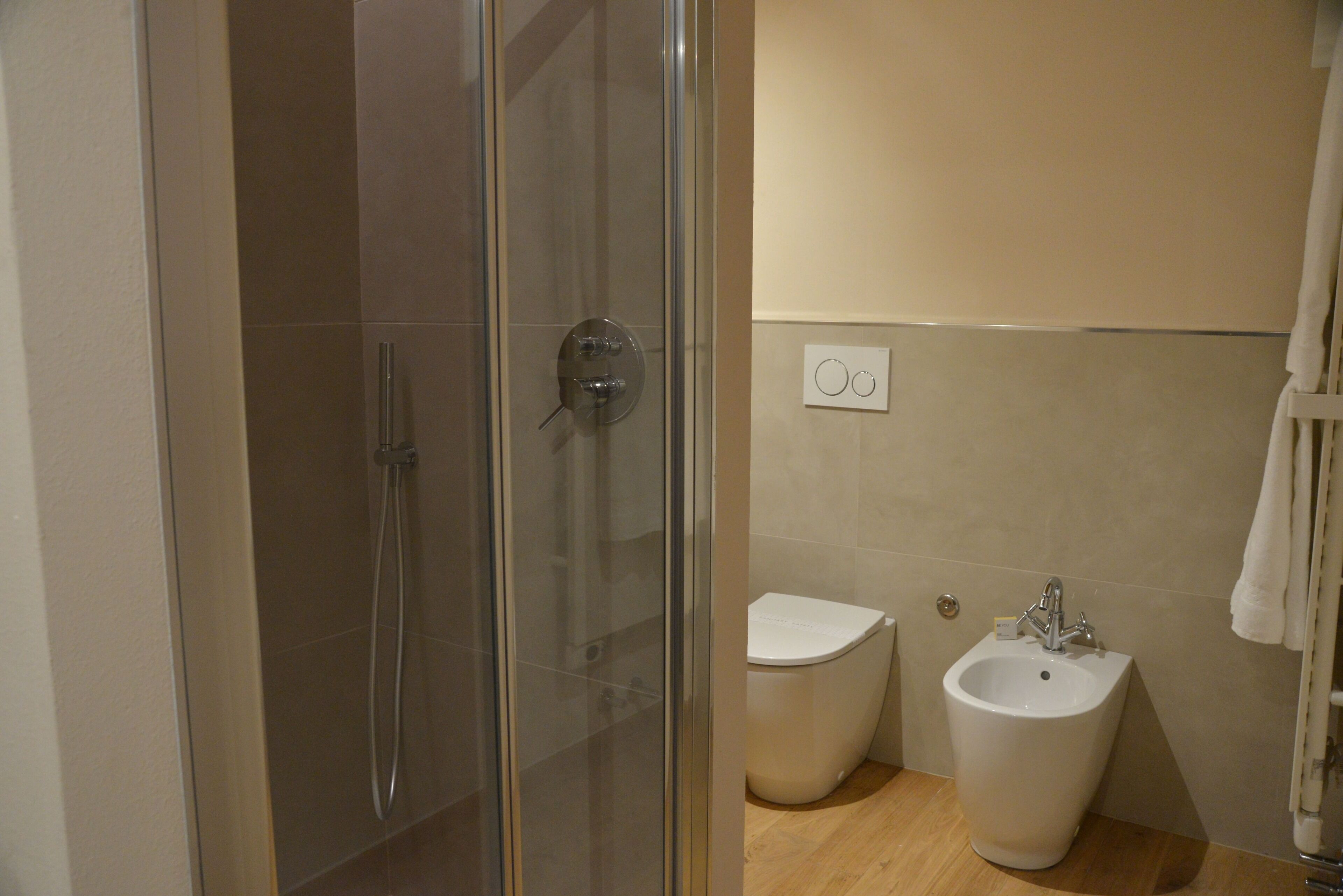 Une salle de bain dotée d’une douche à parois de verre, d’un bidet et d’un lavabo.