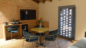 A dining area with a brick wall, a television, and a sliding glass door. - Maranello Resort Borgo della Montina (Maranello)