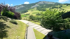 A view from a balcony with a railing, overlooking a green landscape with hills and trees. - Apartment '4-6 Couchages Proche Des Pistes' with Mountain View, Balcony and Wi-Fi (Flumet)