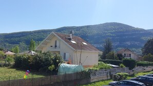 A residential area with houses, a grassy yard, and a mountain in the background. - Studio "Les Cascades" with Mountain View, Balcony, and Wi-Fi (Gaillard)