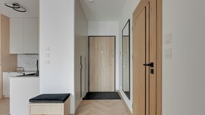 Un interior modern amb cuina, una banca i una porta.