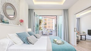 A hotel room with a bed, a small table, a TV, and a balcony with a view of buildings. - Solaga - Centro Alameda (Málaga)