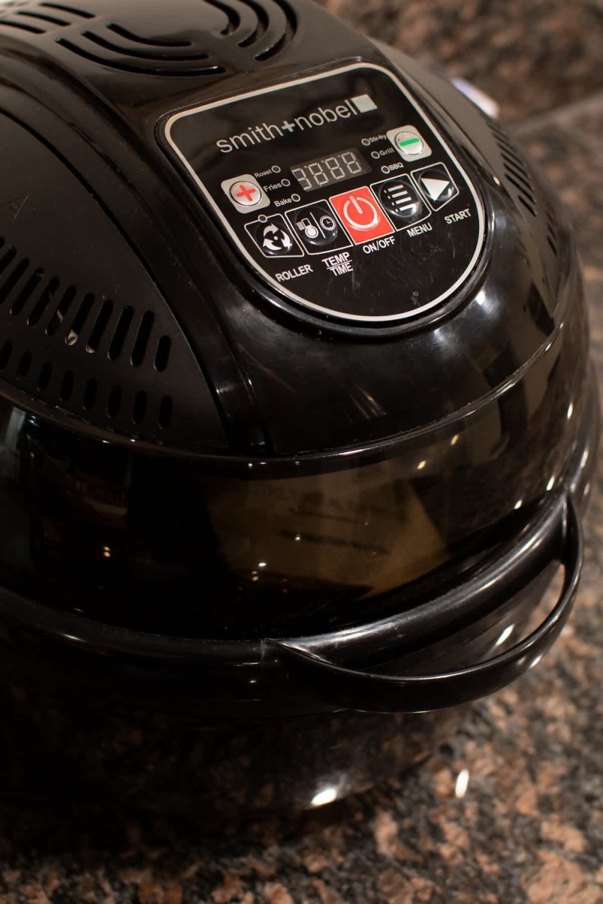 A black electric kettle with a digital display and control buttons.