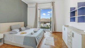 A bedroom with a bed, bedside table, and a view to an outdoor area. - Villa Talamone With Beautiful Sea View (Orbetello)