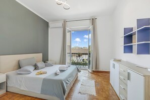 A bedroom with a bed, bedside table, and a view to an outdoor area. - Villa Talamone With Beautiful Sea View (Orbetello)