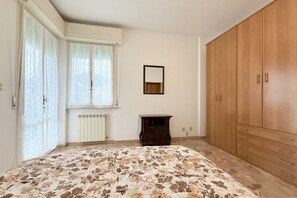 A bedroom with a bed, a wardrobe, a radiator, and a window with curtains. - SE243 - Senigallia, spacious three-room apartment close to the centre and the sea (Senigallia)