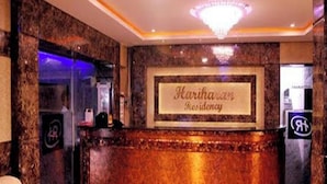 A reception desk with a sign reading 'Karishaan Residency.' - HARIHARAN RESIDENCY (Chennai)