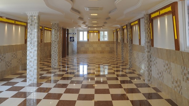 A spacious hallway with checkered flooring, recessed lighting, and patterned walls. - HARIHARAN RESIDENCY (Chennai)