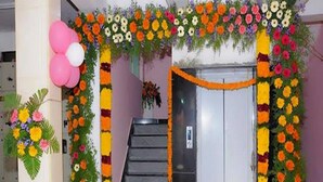 A staircase leading to an elevator, decorated with floral arrangements and balloons. - HARIHARAN RESIDENCY (Chennai)