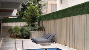 A swimming pool with a tiled edge, a wooden fence, and a metal ladder. - SOHO (Alanya)