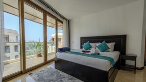 A bedroom with a large bed, a view through floor-to-ceiling windows, and a balcony. - 3-bedroom seaview apartment in Mombasa, close to the beach, with AC (Mombasa)