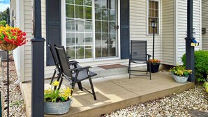 A house with a covered porch, two chairs, and potted plants. - “Friends” Central Perk- Fun Escape - Starved Rock- Ottawa (Ottawa)