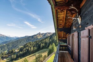 Eine Holzhütte mit einem Balkon mit Blick auf eine Berglandschaft.