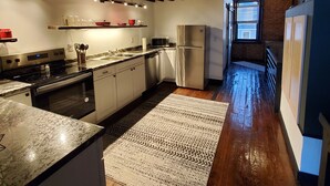 Eine moderne Küche mit einer Granit-Arbeitsplatte, Edelstahlgeräten und Holzboden.