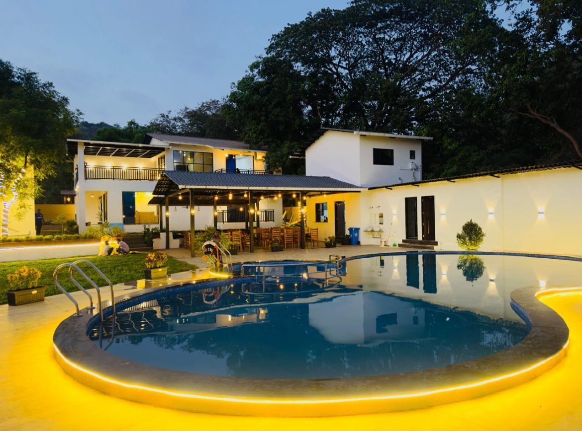 Un hotel moderno con piscina, mobiliario exterior y un edificio de dos pisos.