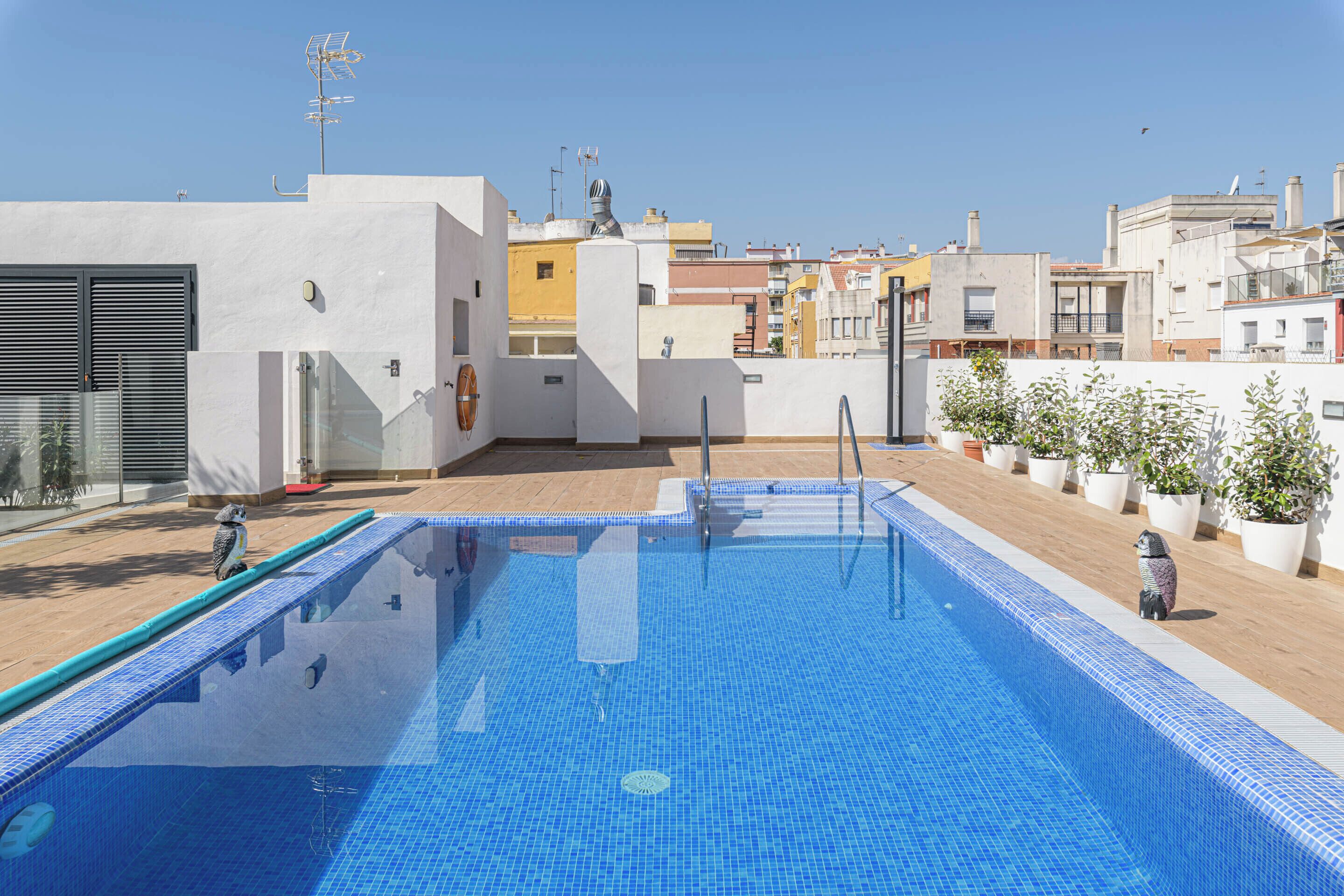 A rooftop swimming pool with a clear view of the surrounding buildings.