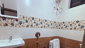 Kylpyhuone, jossa on pesuallas, wc, suihku ja peili.