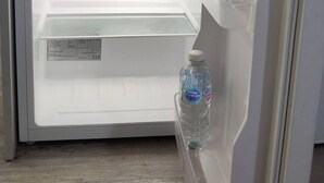 An open refrigerator with a bottle of water inside. - Room-cozy Small Room in City Centre and (Chelmsford)