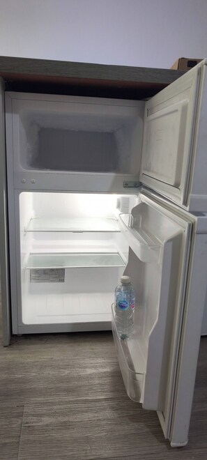 Auki oleva jääkaappi, jonka sisällä on vesipullo.