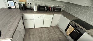 Una cocina con microondas, tostadora y horno empotrado.