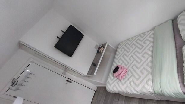 A bedroom with a bed, a desk, and a wardrobe. - Room-cozy Small Room in City Centre and (Chelmsford)