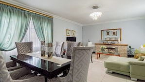 A living room with a fireplace, a dining table, and a sofa. - The Quiet Hidden Gem (Johannesburg)