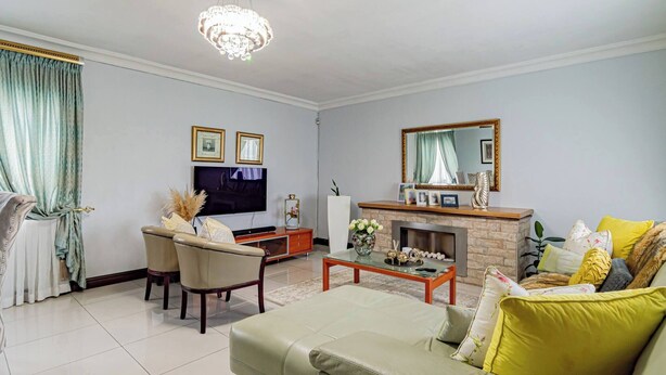 A living room with a television, fireplace, sofa, and dining area. - The Quiet Hidden Gem (Johannesburg)