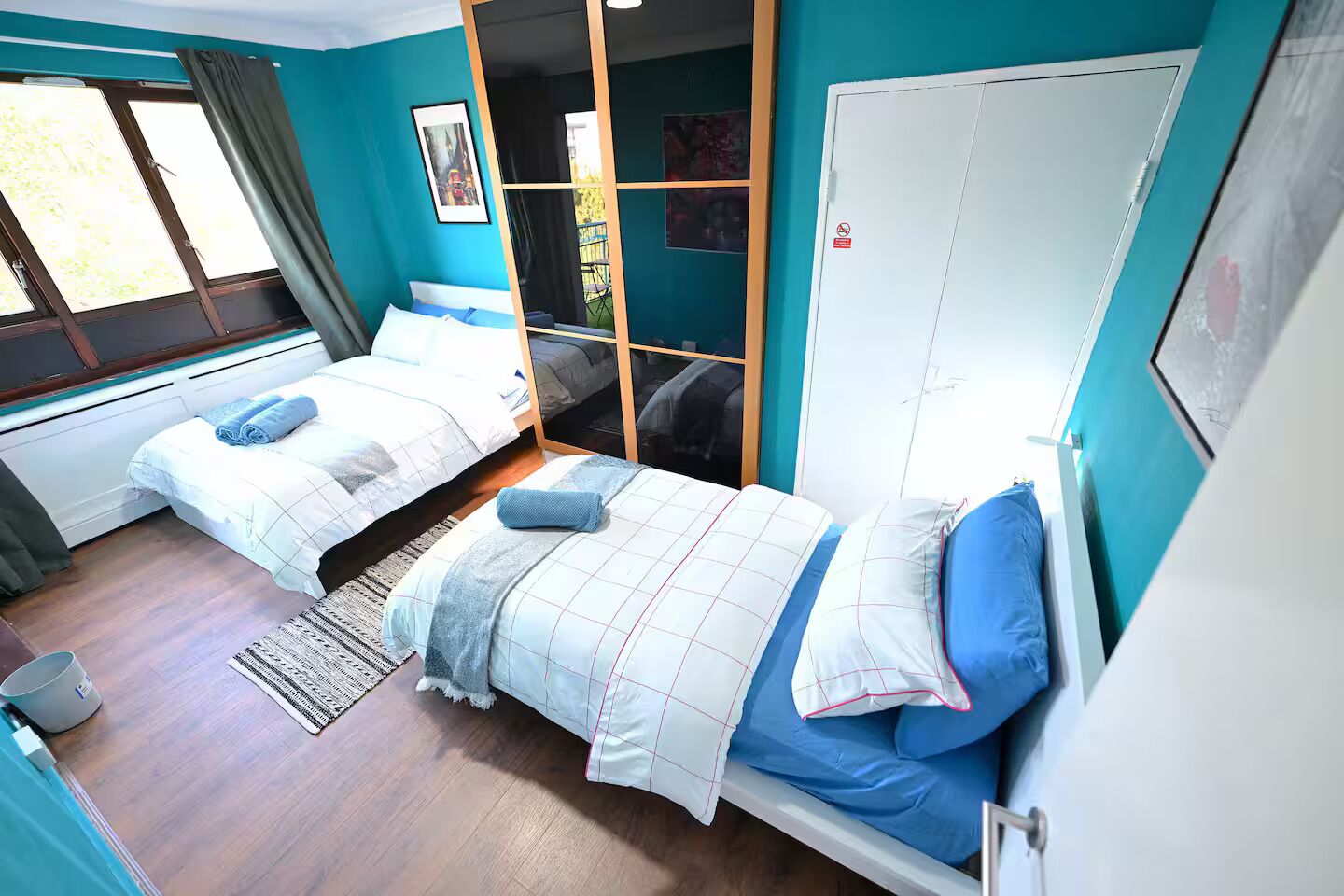 Une chambre avec deux lits, une armoire et une fenêtre.