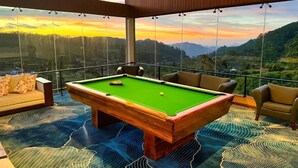 Een pooltafel in een ruimte met uitzicht op een berglandschap.