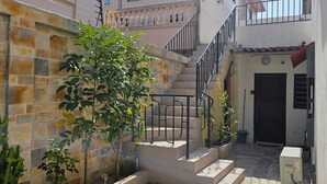 Ein Innenhof mit Fliesenboden, einer Treppe und einem Gebäude mit Balkon.