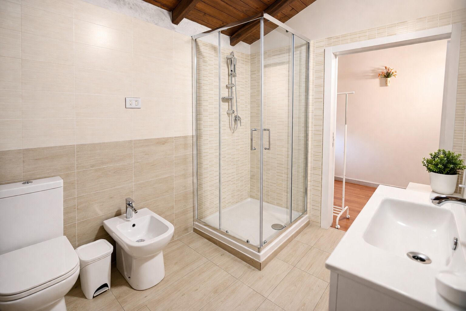Bany modern amb vàter, bidet, dutxa amb envàs de vidre i un rentapeus.