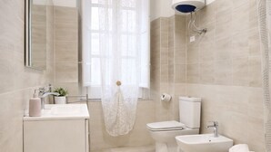 Un baño moderno con inodoro, bidé, lavabo y ducha.