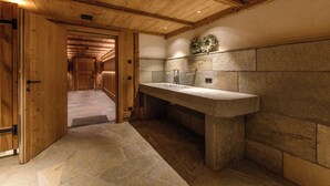 A wooden interior with a stone sink and a door leading to a hallway. - Berghaus Gauertal (Tschagguns)