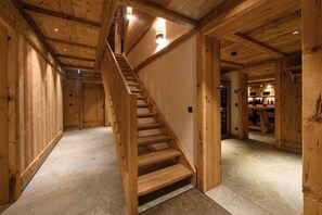 Ein Holzinnenraum mit Treppe, Steinböden und Holzwänden.