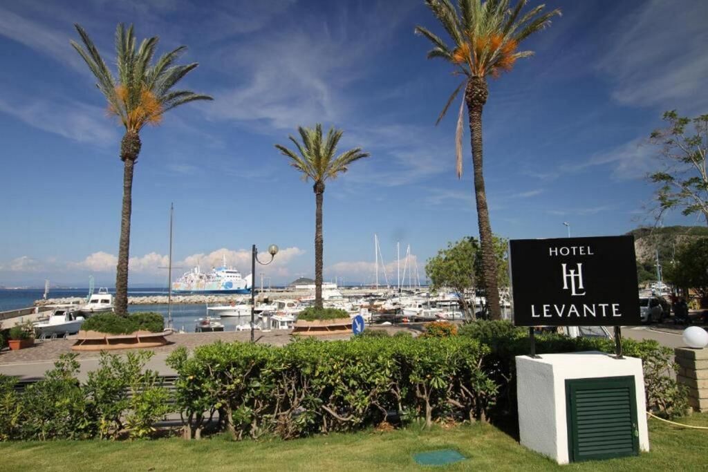 A hotel sign, palm trees, and a marina with boats.