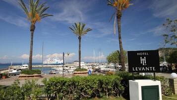 A hotel sign, palm trees, and a marina with boats.