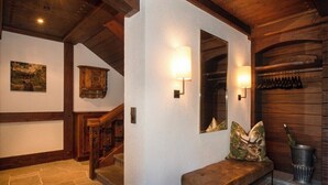 Eine Holztreppe, eine Bank mit Zierkissen und Wandleuchten.