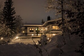 A snow-covered building with multiple windows and a balcony, surrounded by trees. - Waldhaus Rappakopf (Tschagguns)