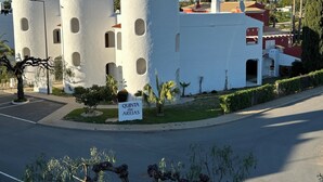 Edifici amb tres torres cilíndriques, un rètol que diu 'QUINTA das AREIAS' i un pàrquing.